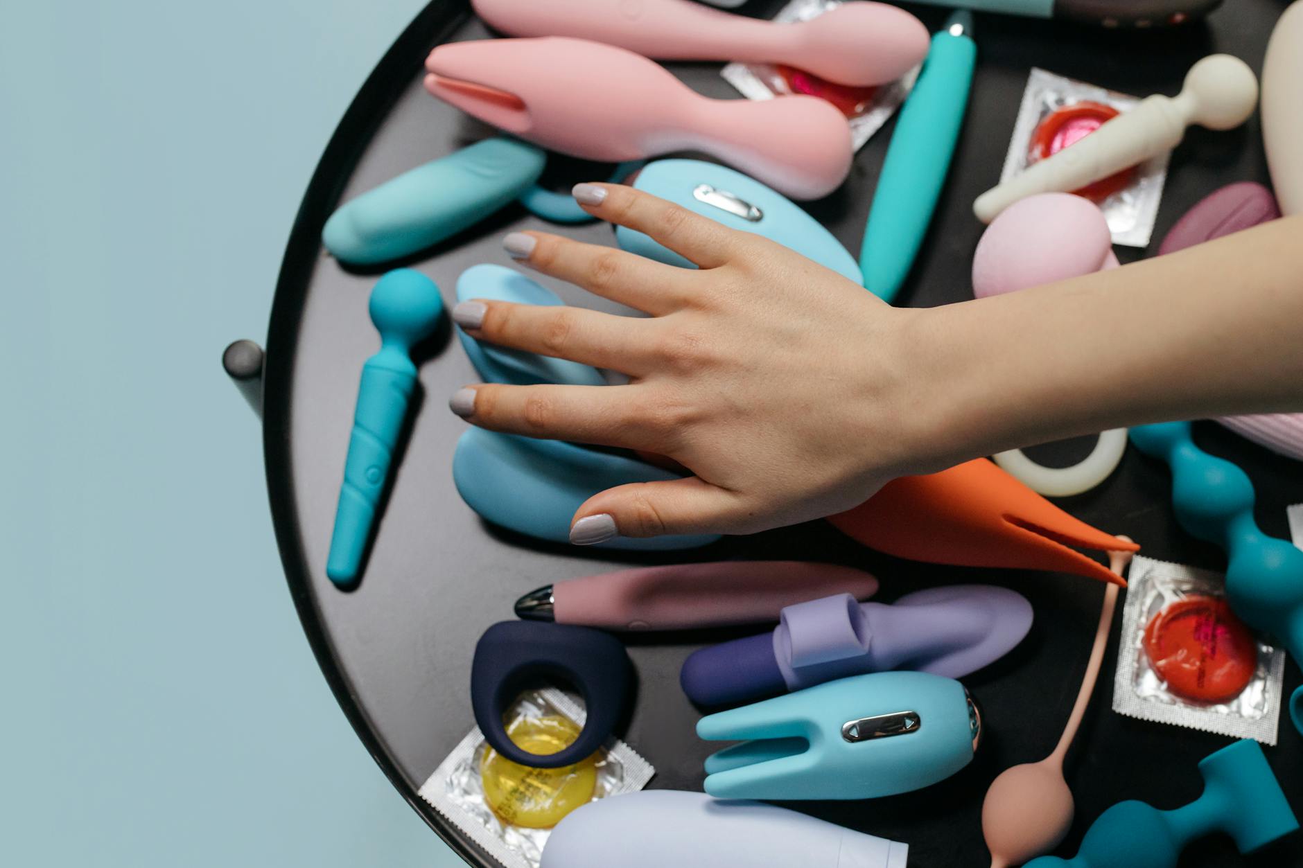 Close-up of hands holding a sleek vibrator, representing restored sensation and intimate self-care.