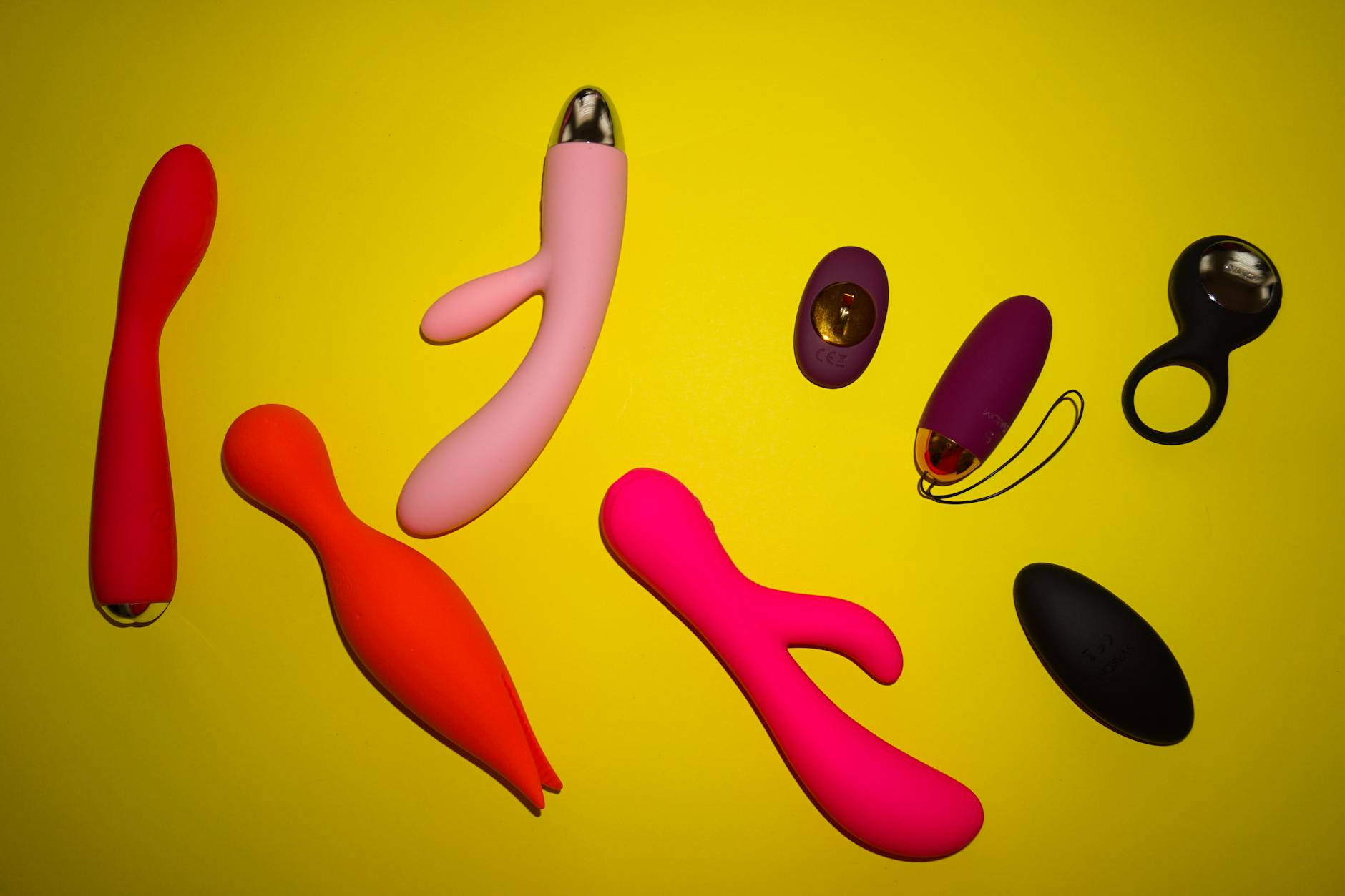 Woman thoughtfully holding blue and pink silicone vibrators
